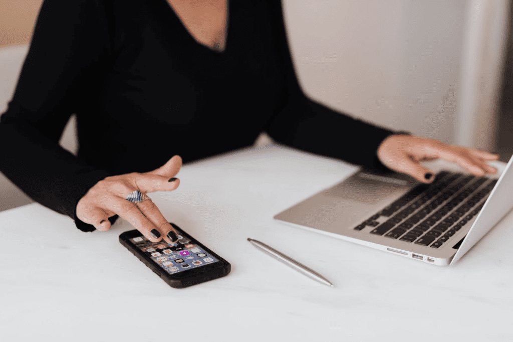 woman using mobile and laptop