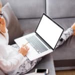 Woman sitting on a sofa working on laptop