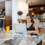 Woman working on a laptop in an upscale cafe
